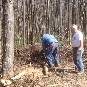 Two members of the Antrim County Snowmobile Club cutting trees and clearing brush from a new trail, access donated by local business owners to eliminate issues with a local homeowner.