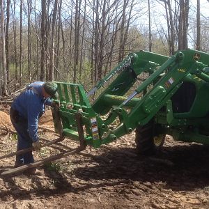 A club member prepping the tractor to move stumps and heavier trunk sections.