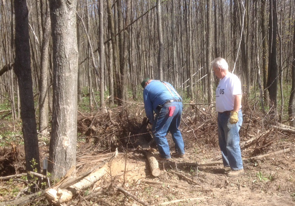 Two members of the Antrim County Snowmobile Club cutting trees and clearing brush from a new trail, access donated by local business owners to eliminate issues with a local homeowner.